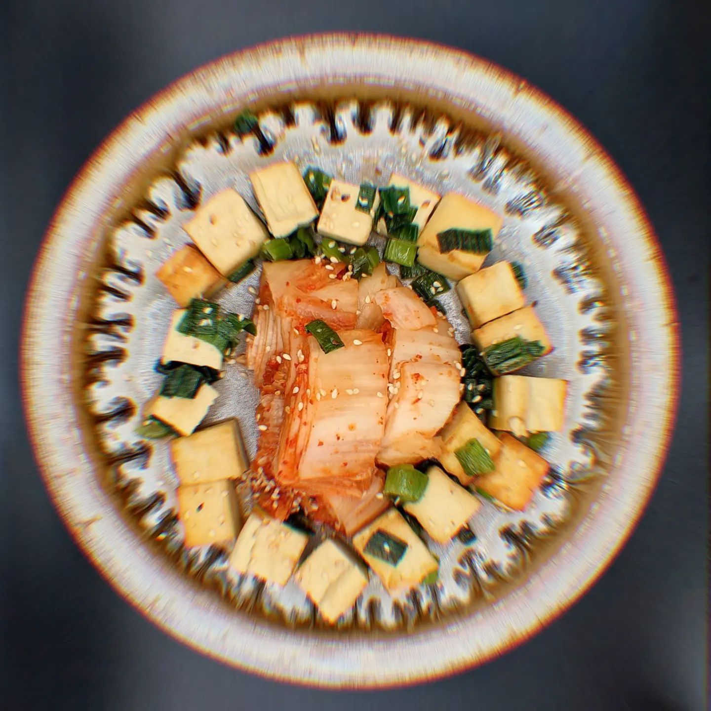 Un gros plan d'une assiette de nourriture avec du tofu et du kimchi