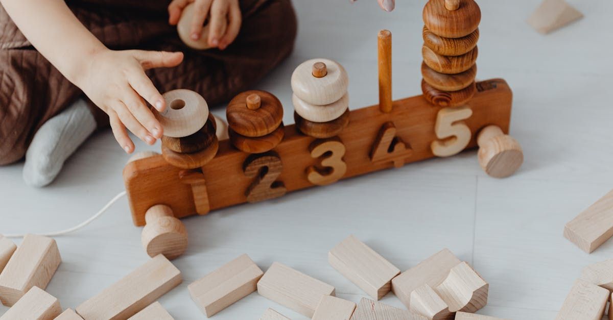 A child is playing with a wooden toy with numbers on it.