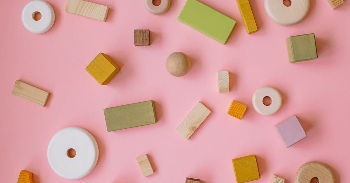 There are many different types of wooden blocks on a pink background.