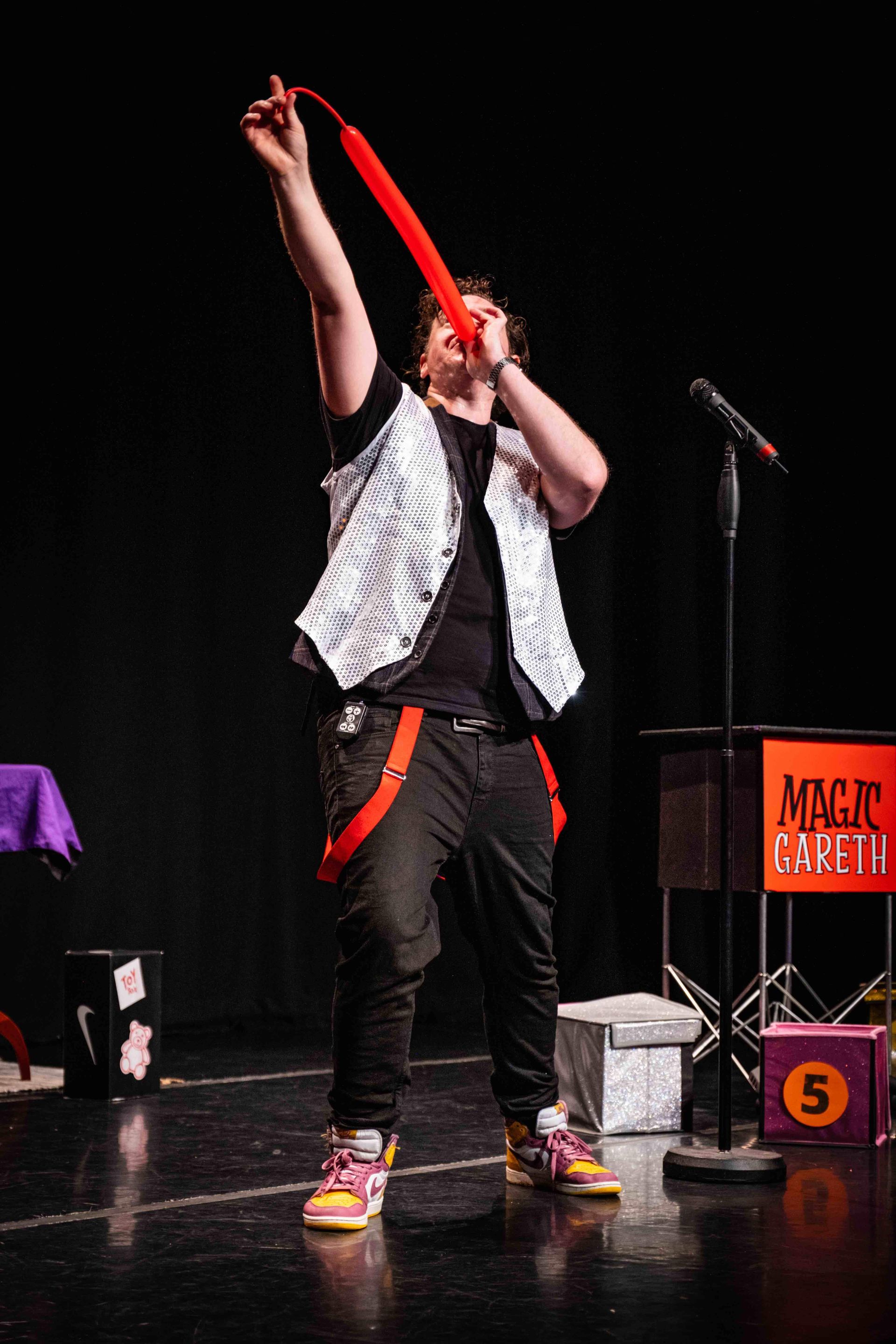 Magic Gareth performing an interactive magic trick with a balloon at a family festival.