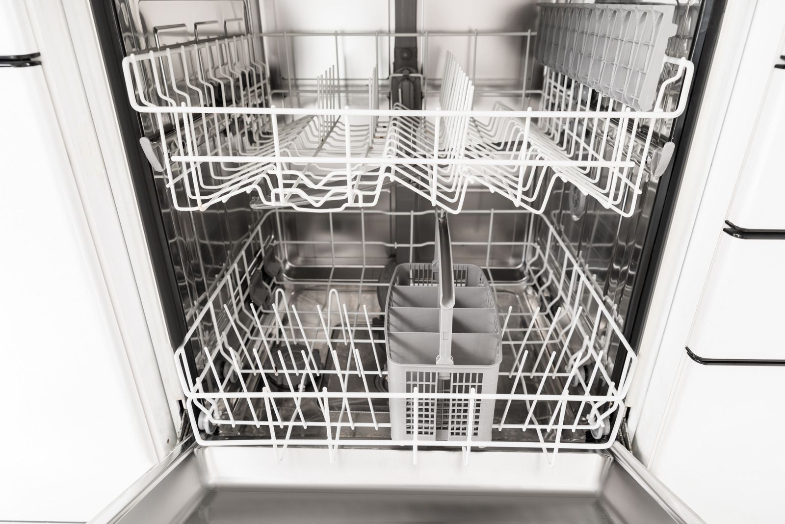 Empty dishwasher with racks and utensil basket.
