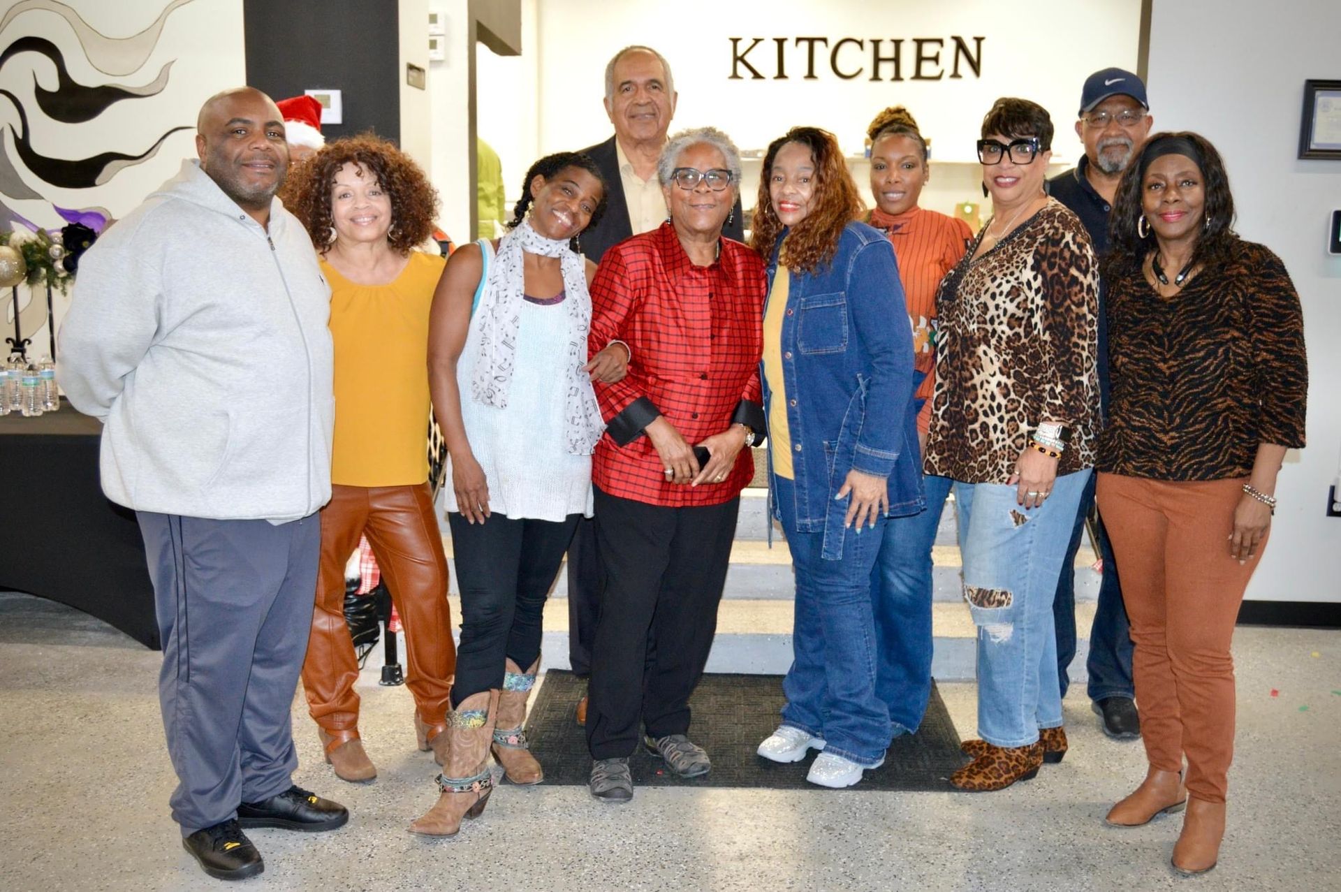 A group of people standing in front of a kitchen sign