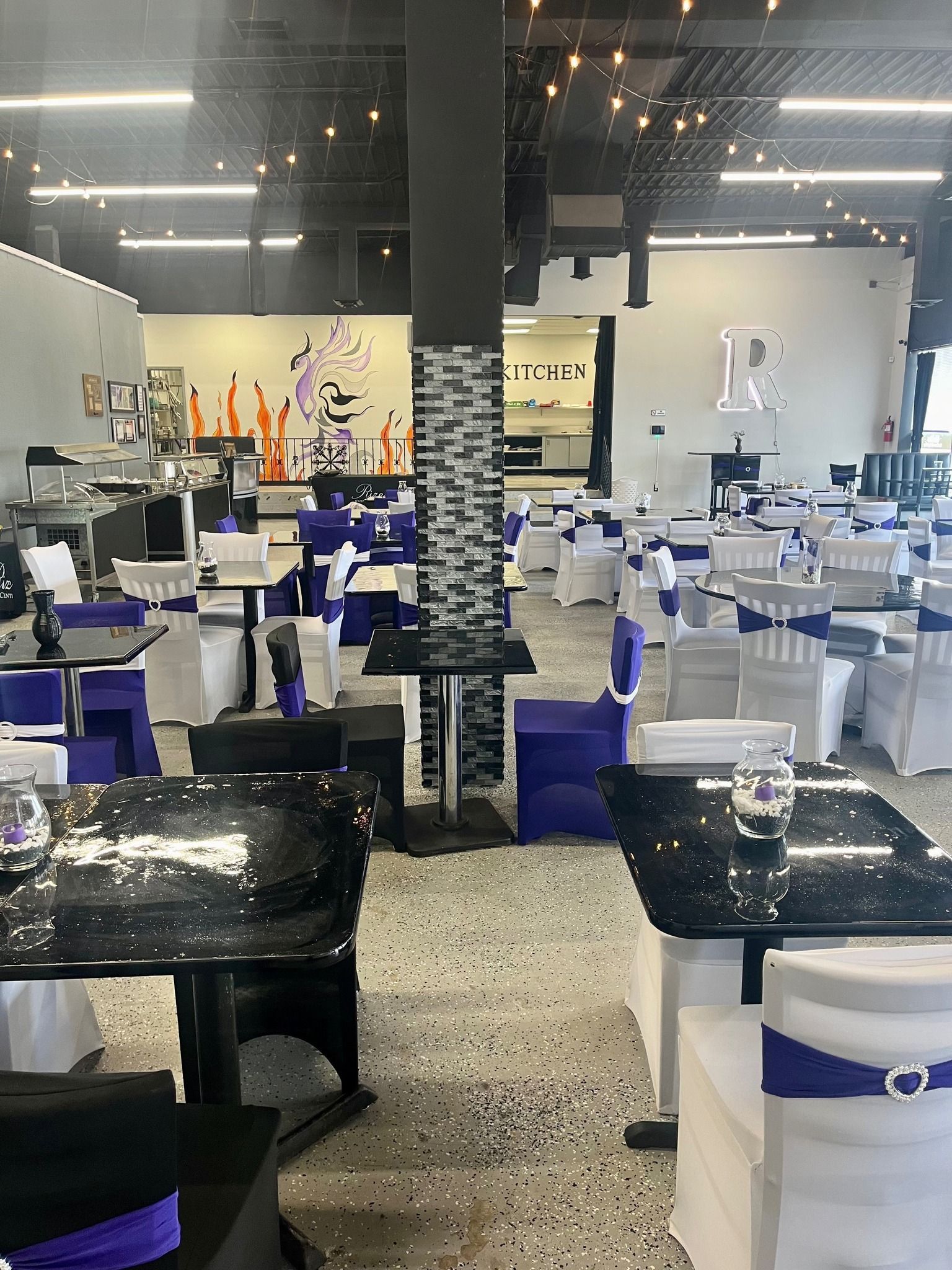 A large room with tables and chairs set up for a wedding reception.