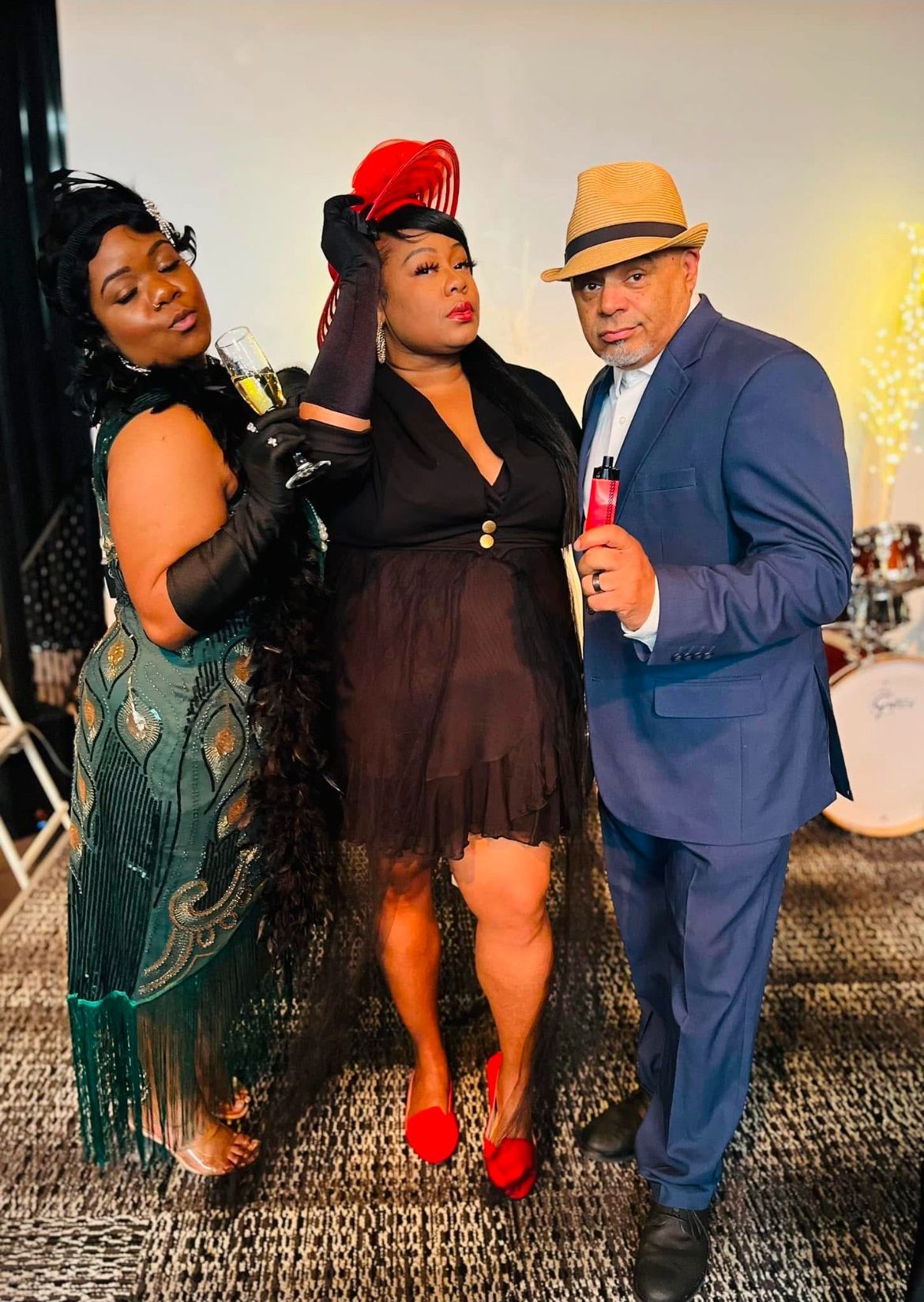 A man in a suit and two women in dresses are posing for a picture.