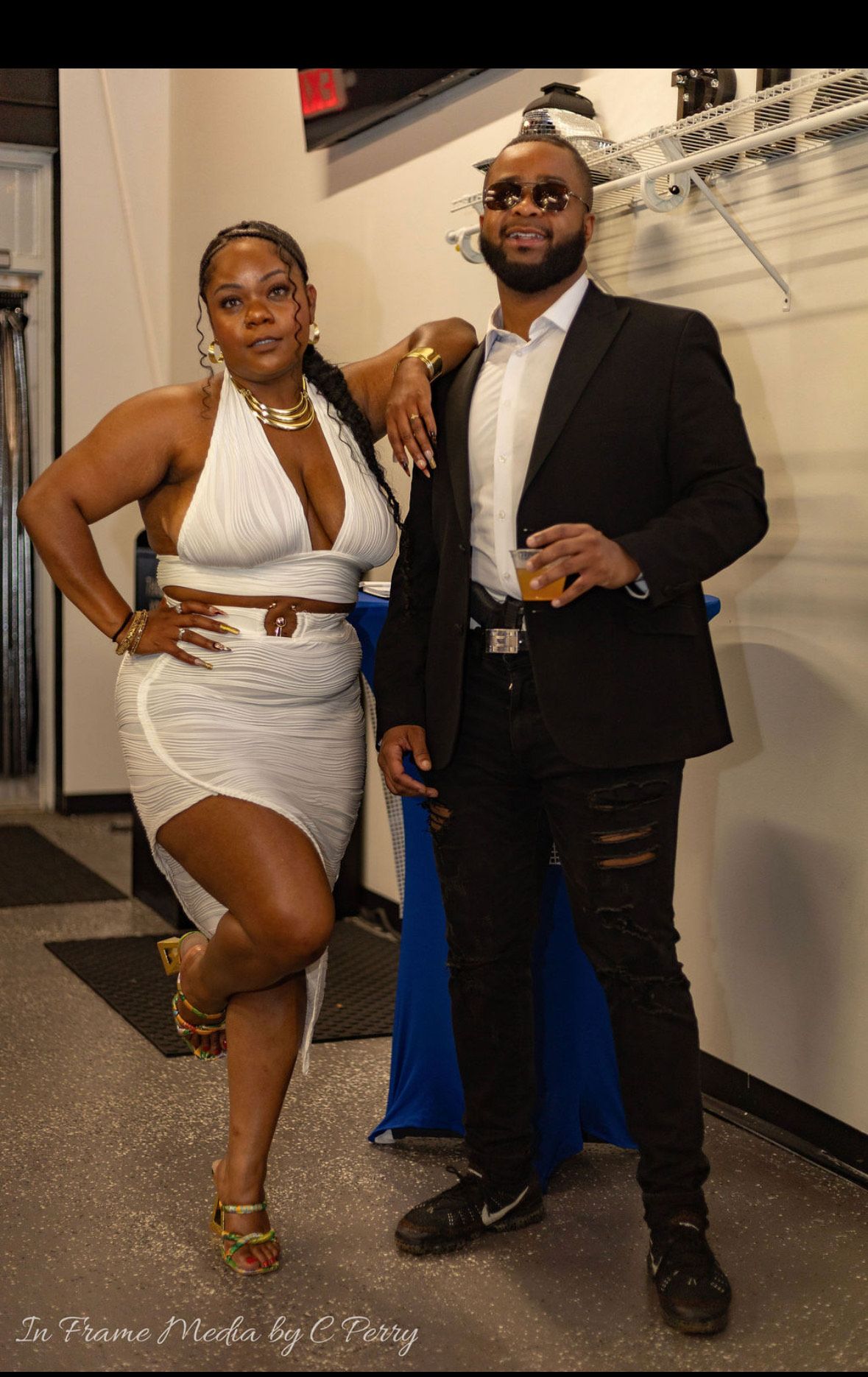A man in a suit and a woman in a white dress are posing for a picture.