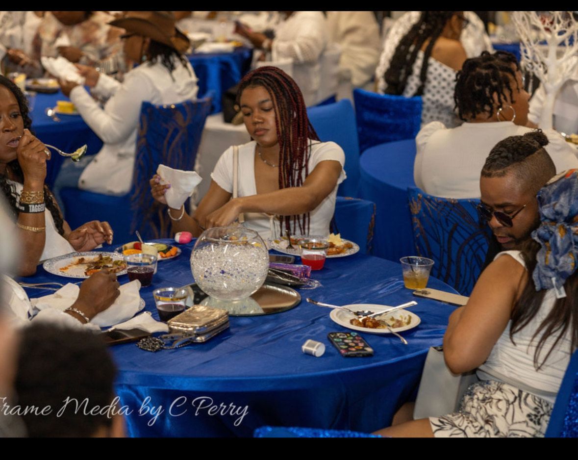 A group of people are sitting at tables with plates of food.