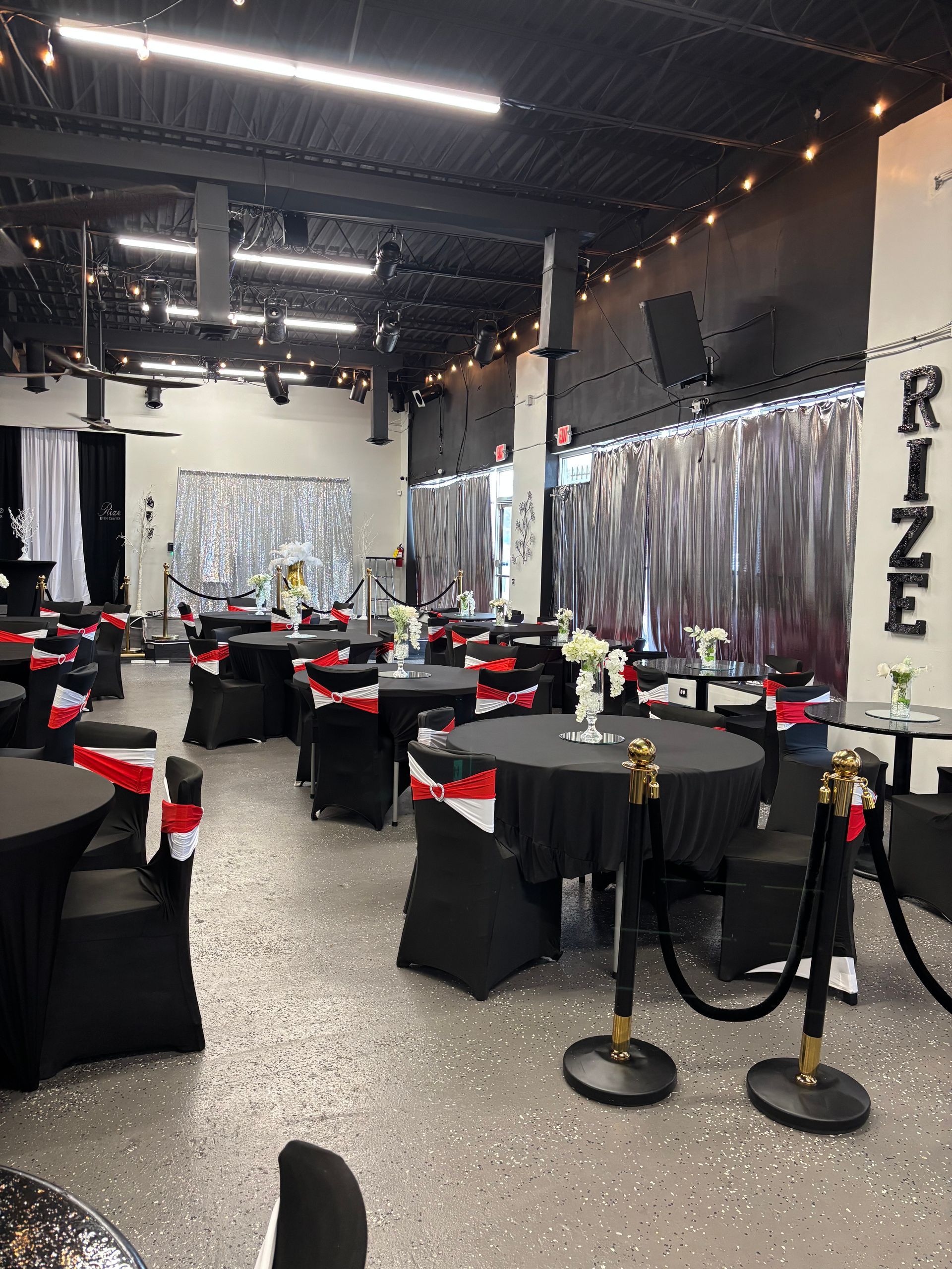 A large room with tables and chairs set up for a party.