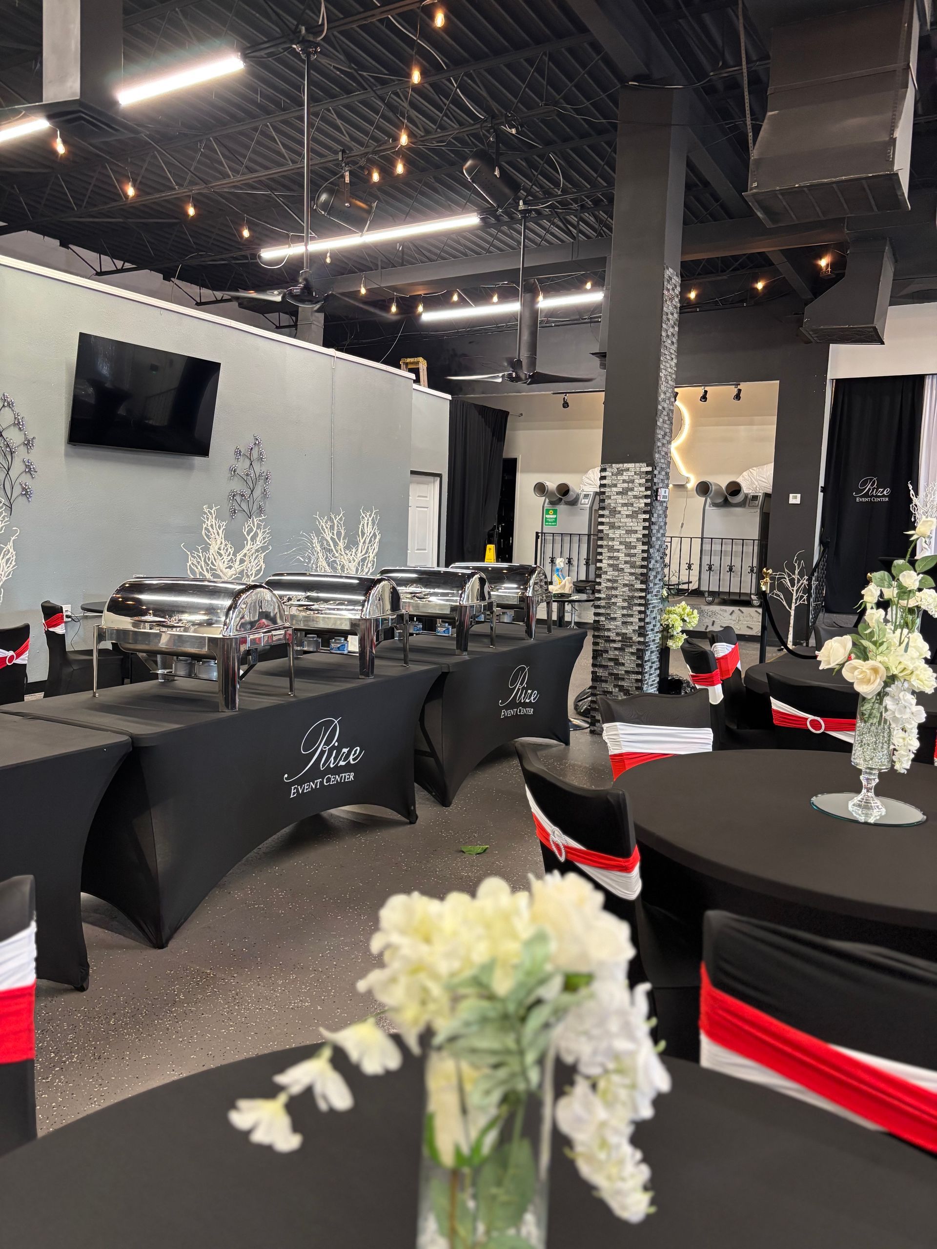 A room with tables and chairs and a vase of flowers