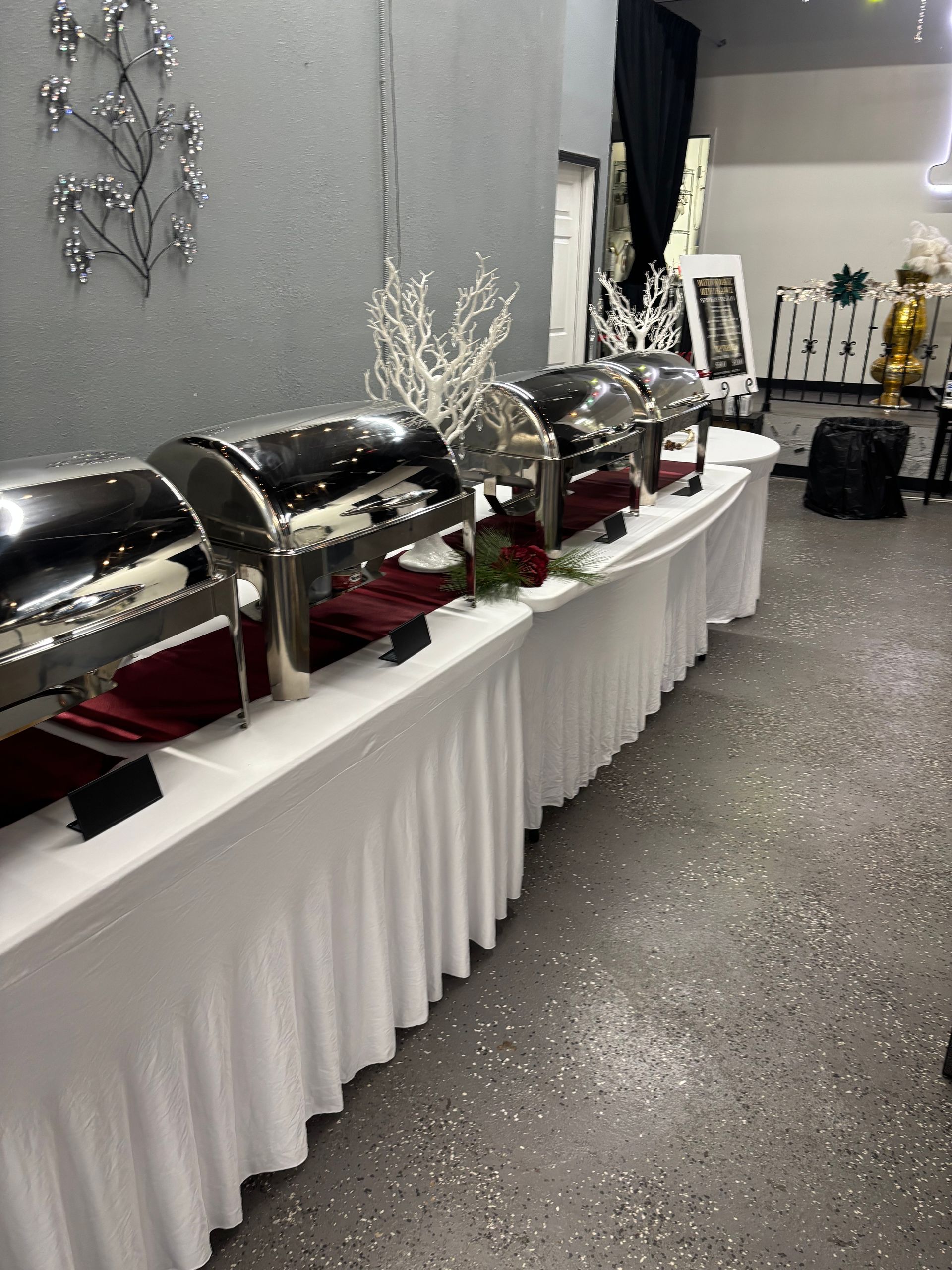 A large room with tables and chairs set up for a party with a large letter r on the wall.