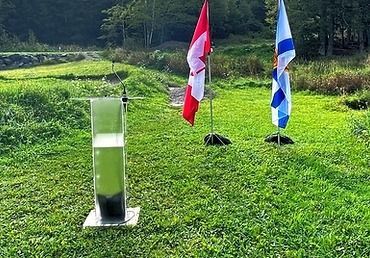 A podium in the middle of a grassy field with two flags in the background.