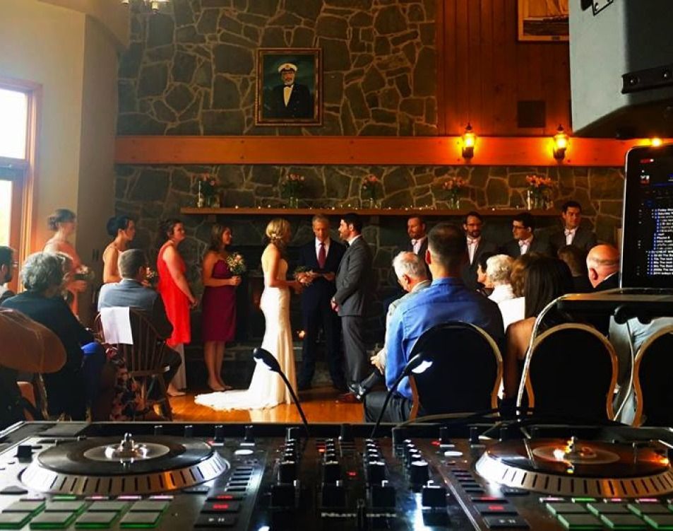 A bride and groom are getting married in front of a crowd at a wedding reception.