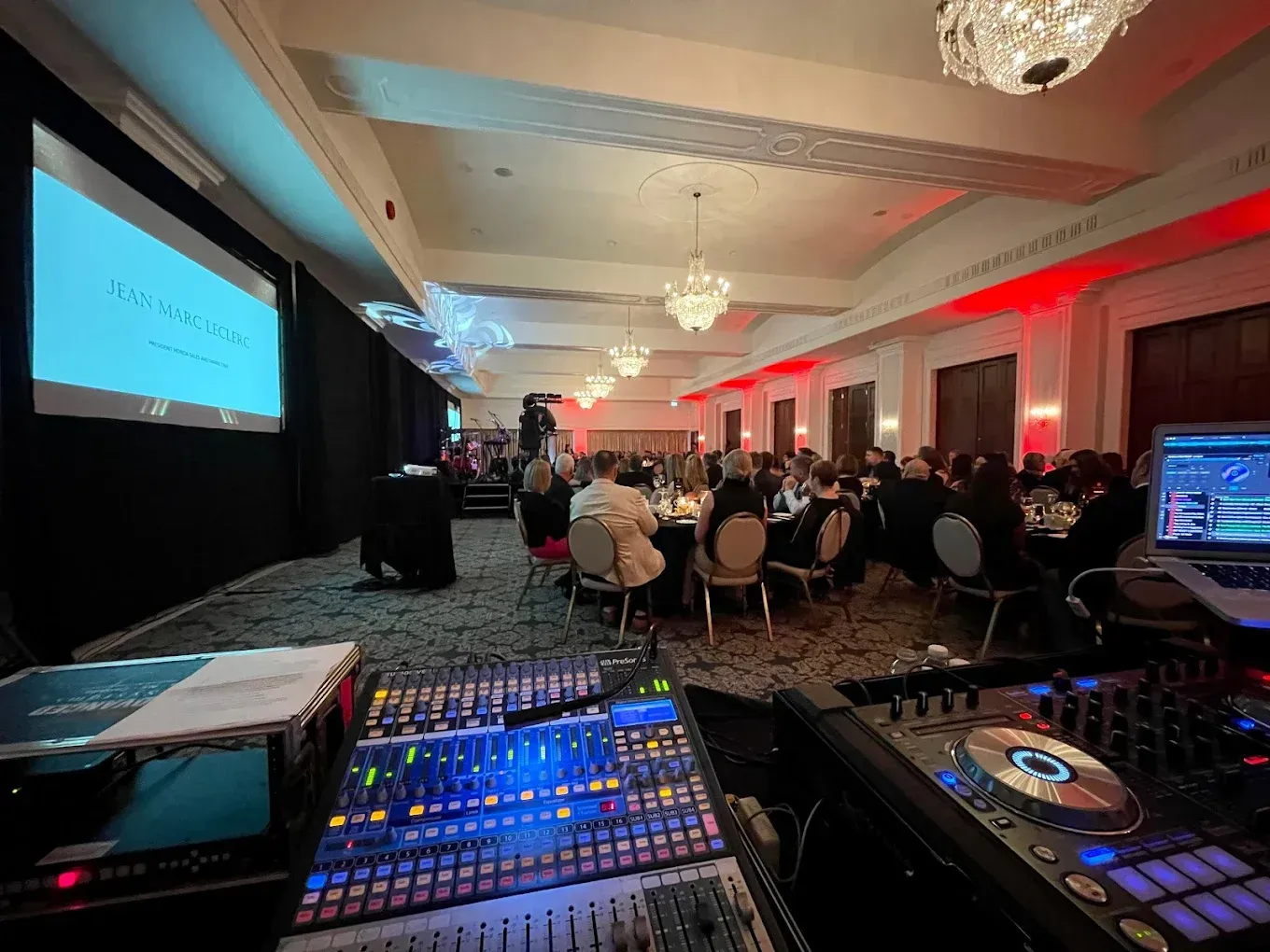 A group of people are sitting at tables in a large room.