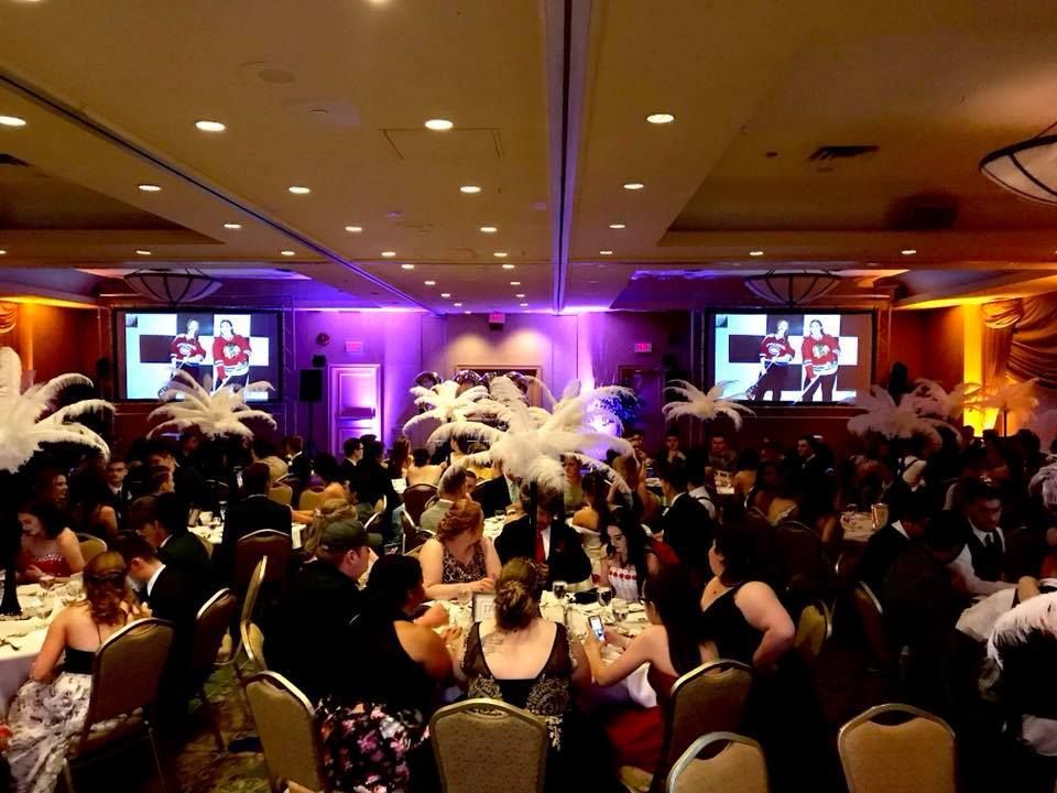 A large room with a lot of people sitting at tables.