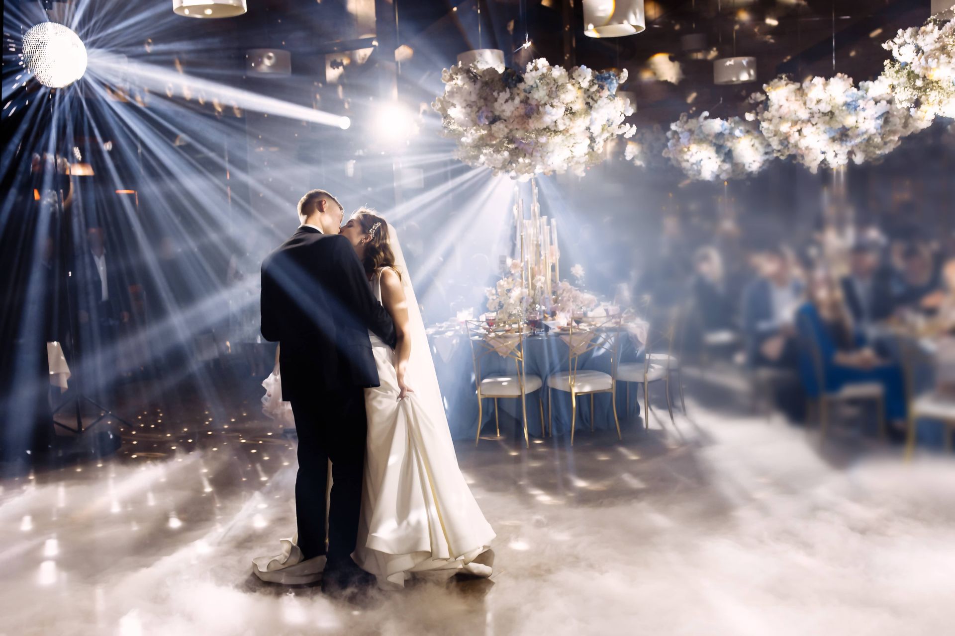 A bride and groom are dancing their first dance at their wedding reception.