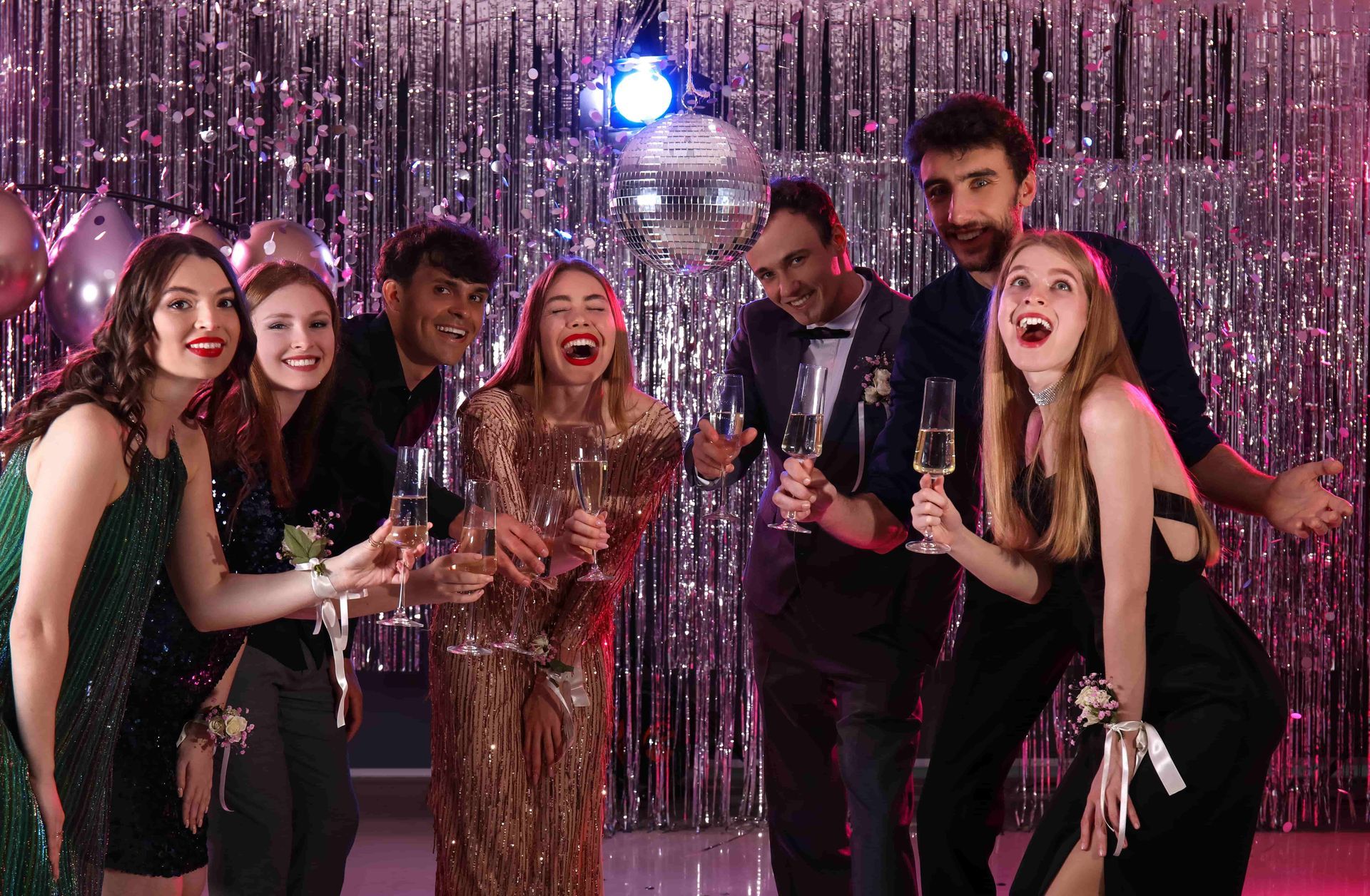 A group of people are standing next to each other at a party holding champagne glasses.