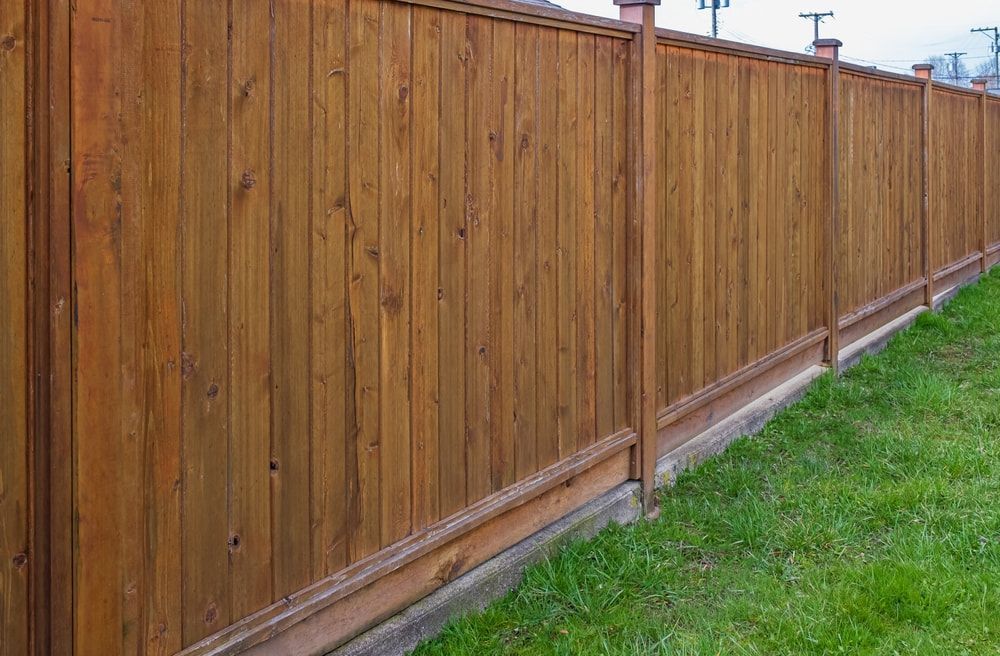 A wooden fence is sitting on top of a lush green lawn. — We Do Fencing in Sunshine Acres, QLD