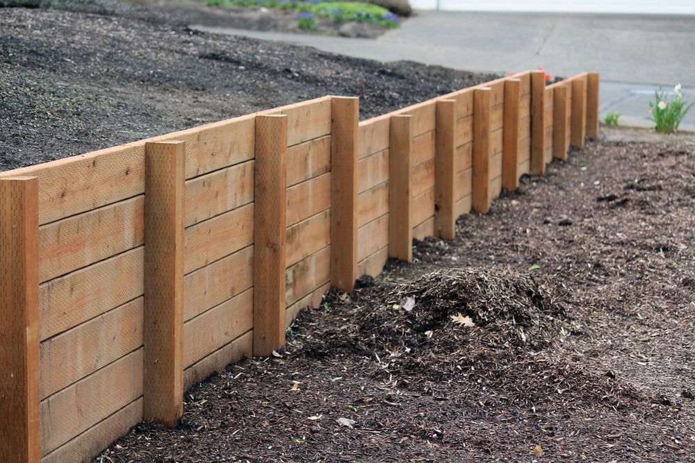 A wooden fence is sitting on top of a pile of dirt. — We Do Fencing in Sunshine Acres, QLD