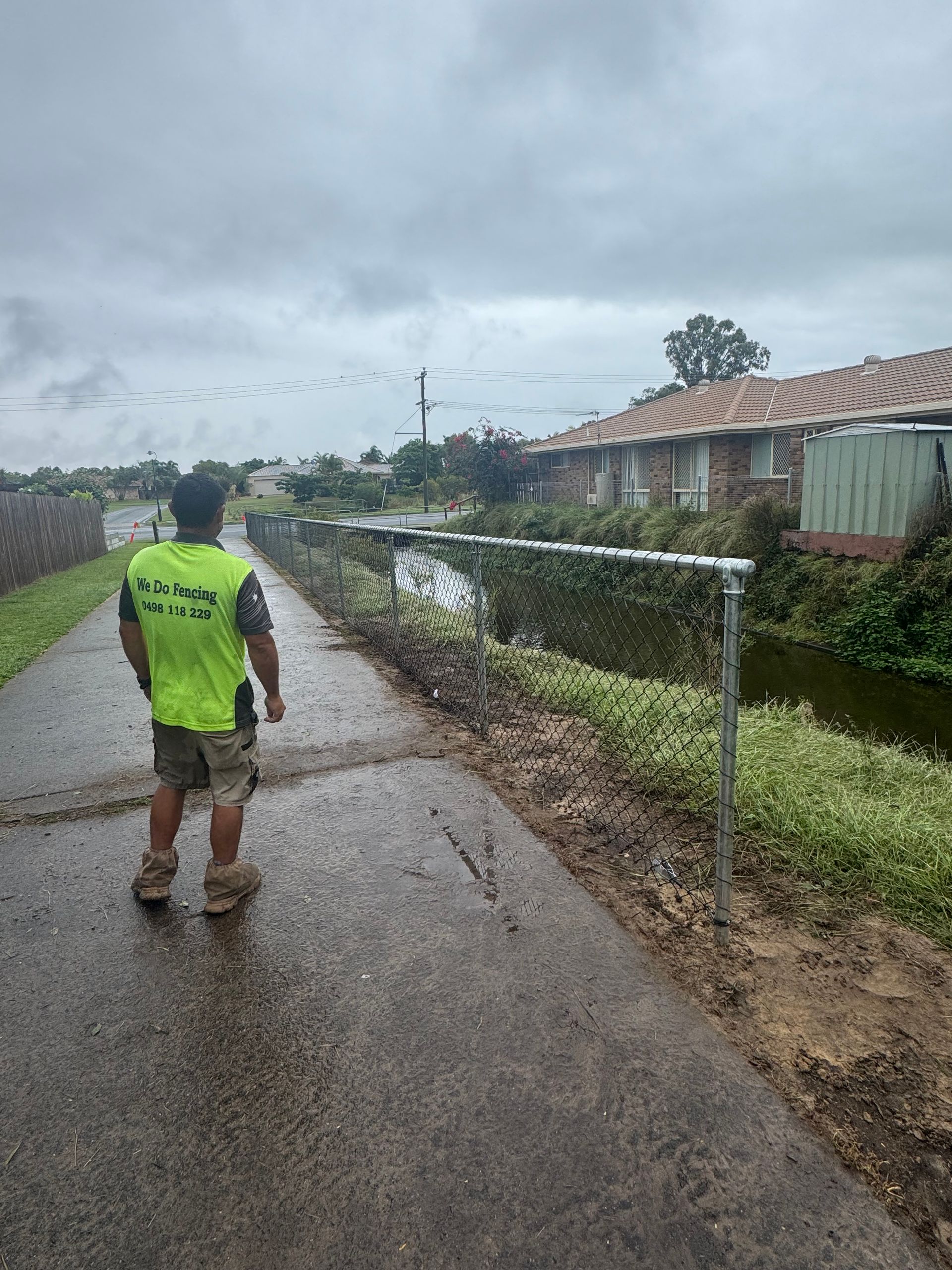 Man Looking At An Aluminium Chain Link Fence — We Do Fencing in Sunshine Acres, QLD