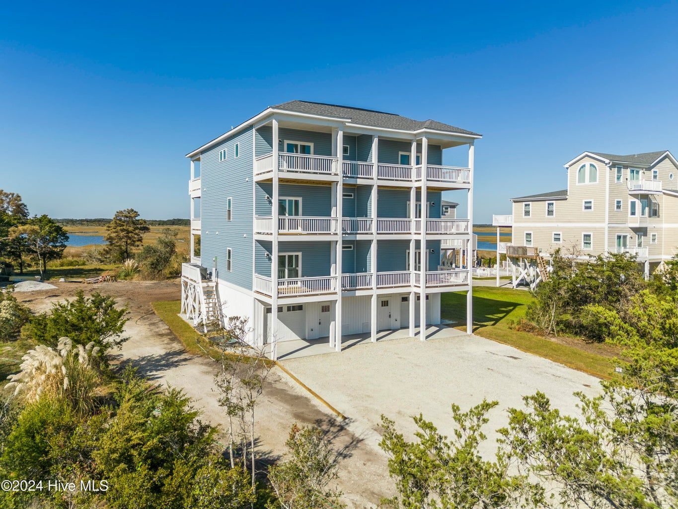 An aerial view of a large house with a lot of balconies surrounded by trees.