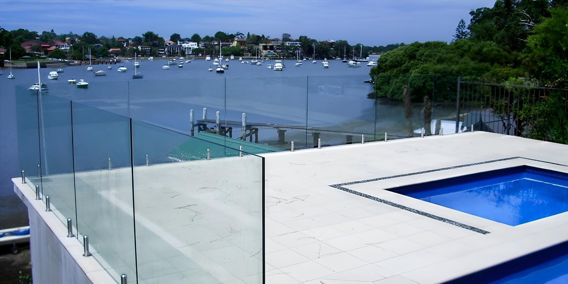 A Swimming Pool With A Glass Railing Overlooking A Body Of Water — Cape Byron Glass In Lennox Head, NSW