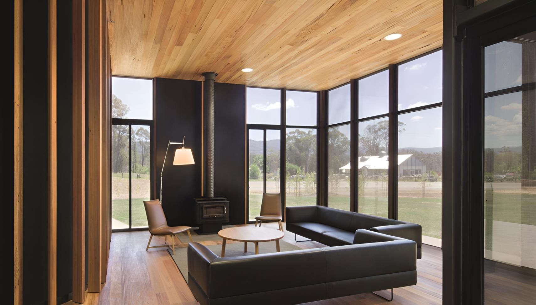 A Living Room With A Couch , Table , Chairs And A Fireplace — Cape Byron Glass In Ocean Shores, NSW