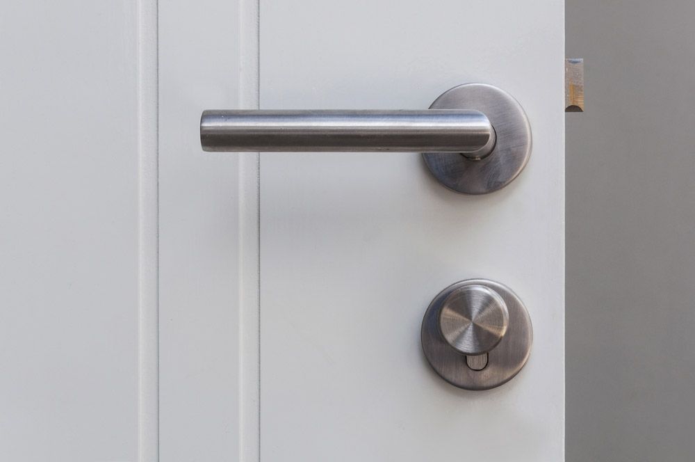 A Close Up Of A Stainless Steel Door Handle On A White Door — Cape Byron Glass In Byron Bay, NSW