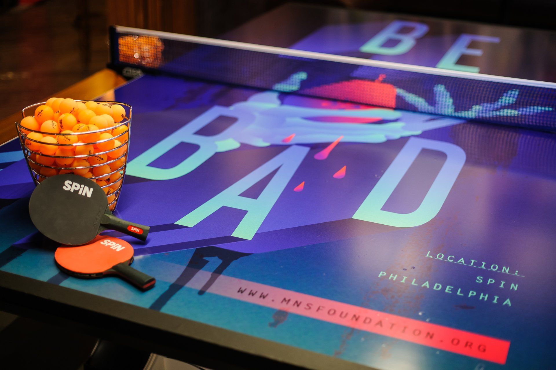 A ping pong table with a sign that says be bad