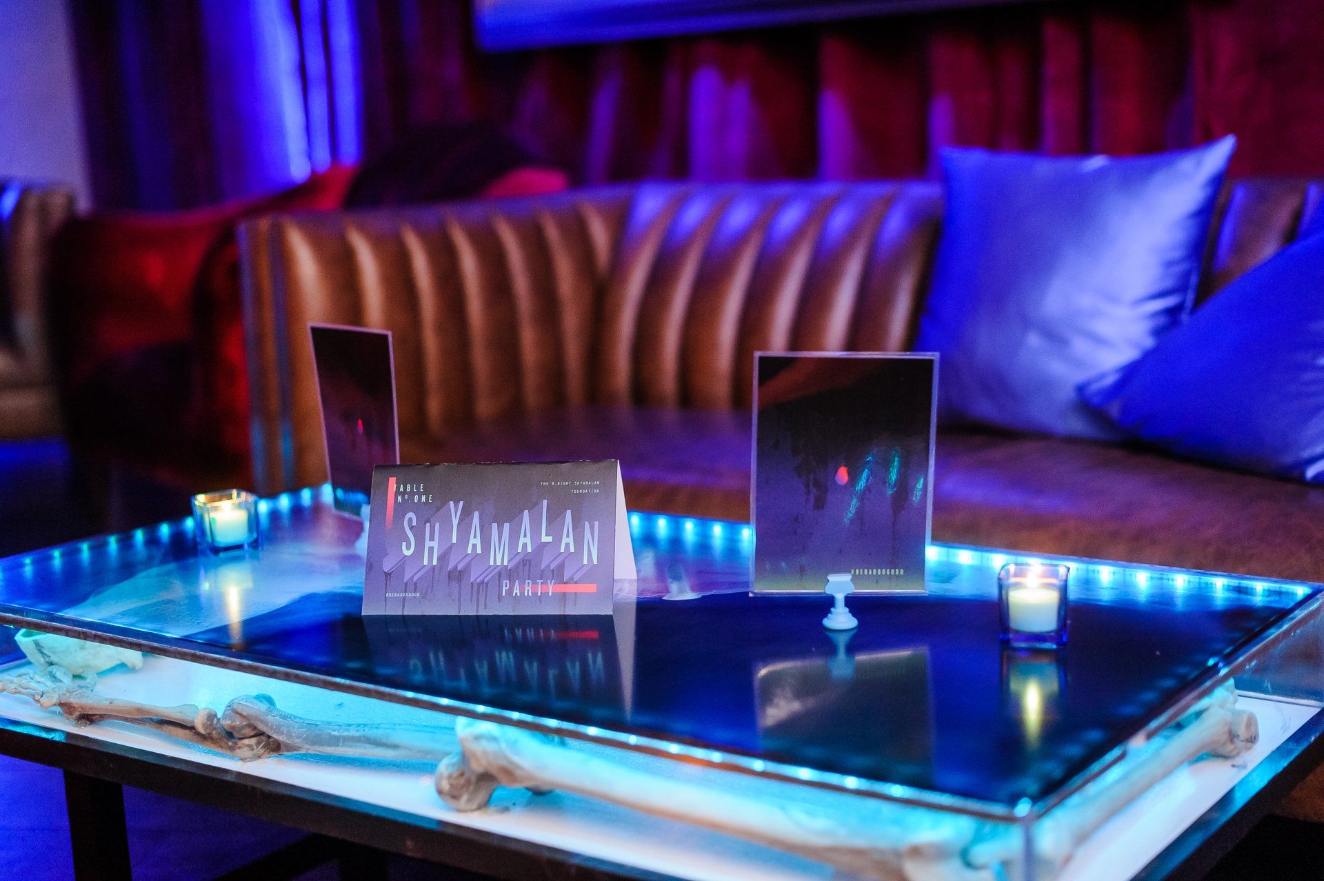 A glass table with a sign on it in a room with a couch.