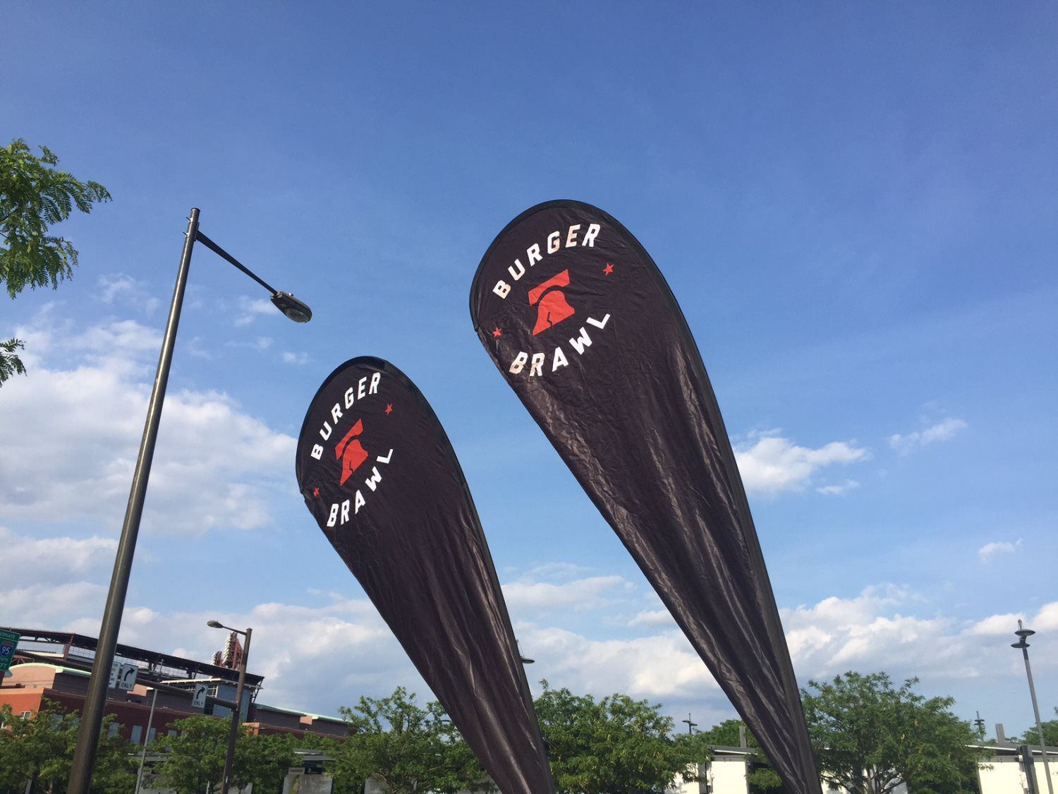 Two flags for burger crawl are hanging from a street light