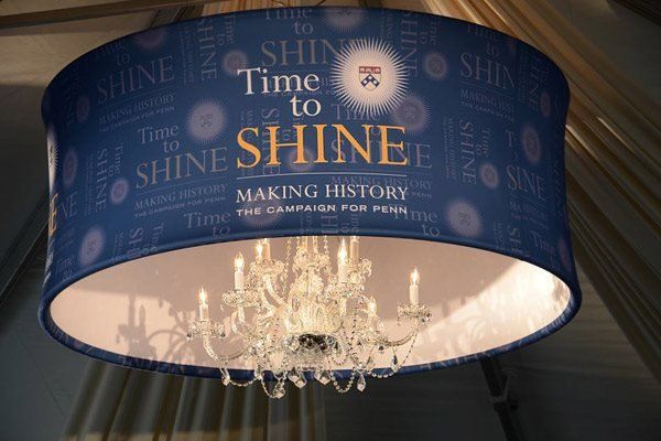 A chandelier with a blue shade that says time to shine