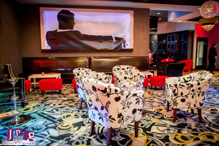 A room with chairs and tables and a painting of a man on the wall