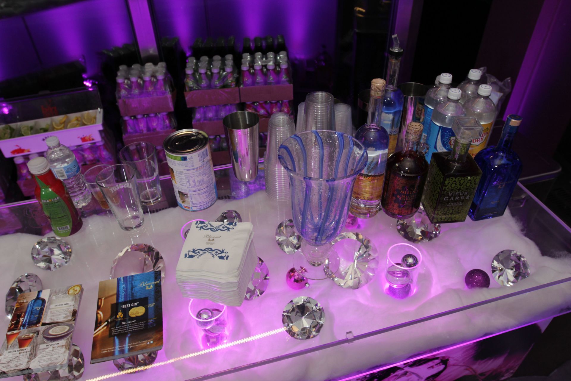 A table with a lot of bottles and glasses on it.