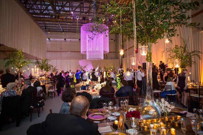 A group of people are sitting at tables in a large room at a wedding reception.
