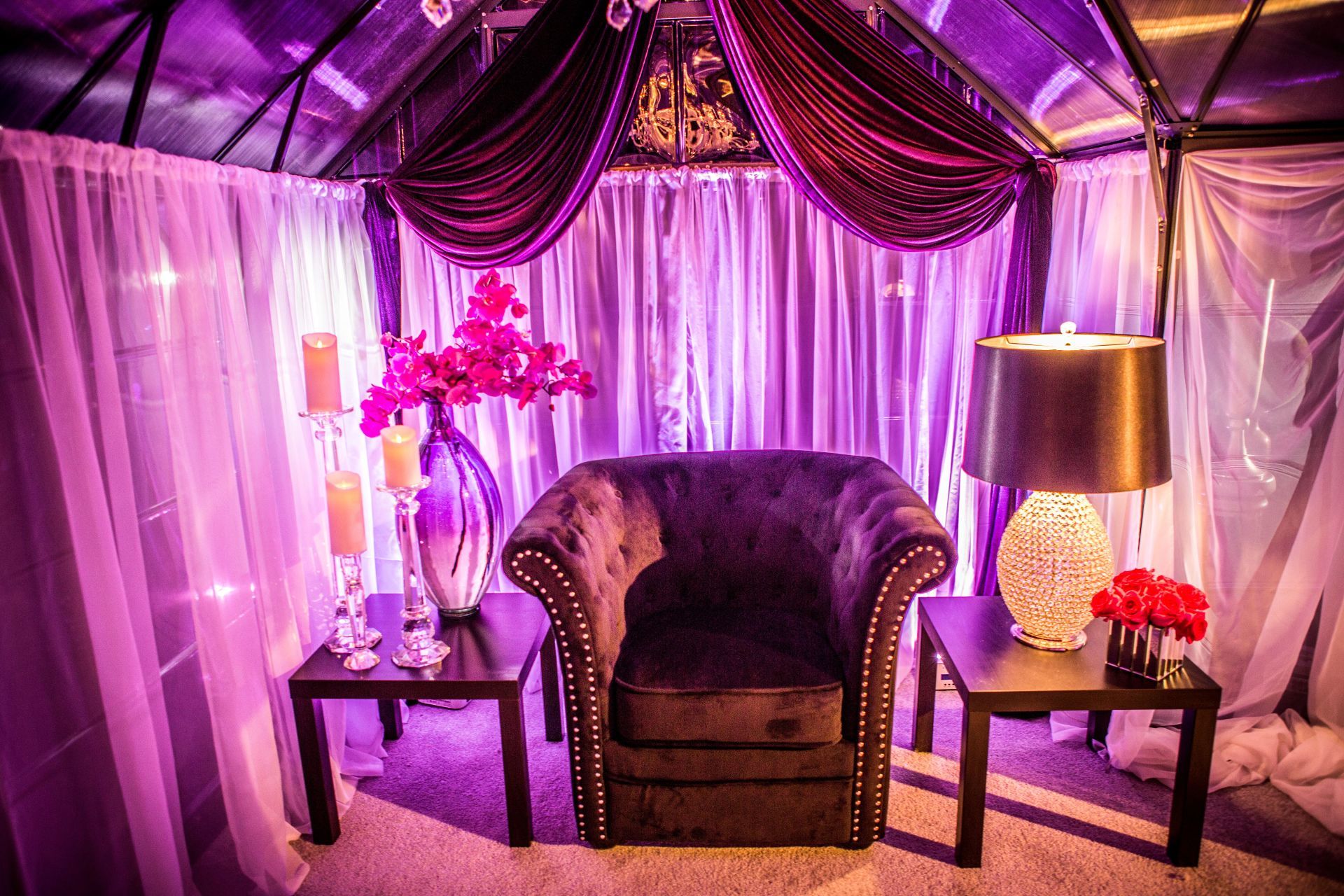 There is a chair in the middle of the room with purple lights behind it.