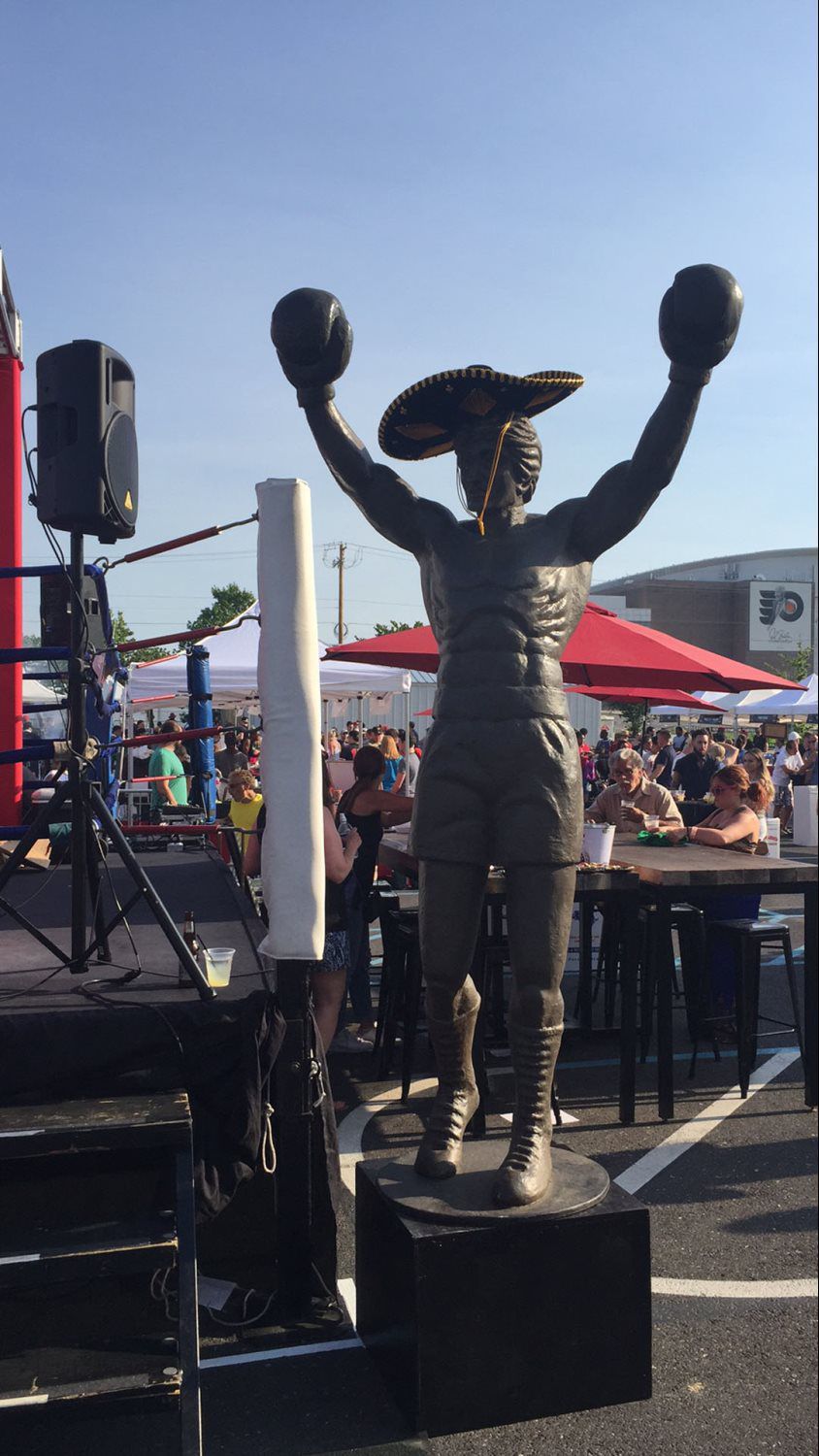 A statue of a boxer wearing a sombrero and boxing gloves