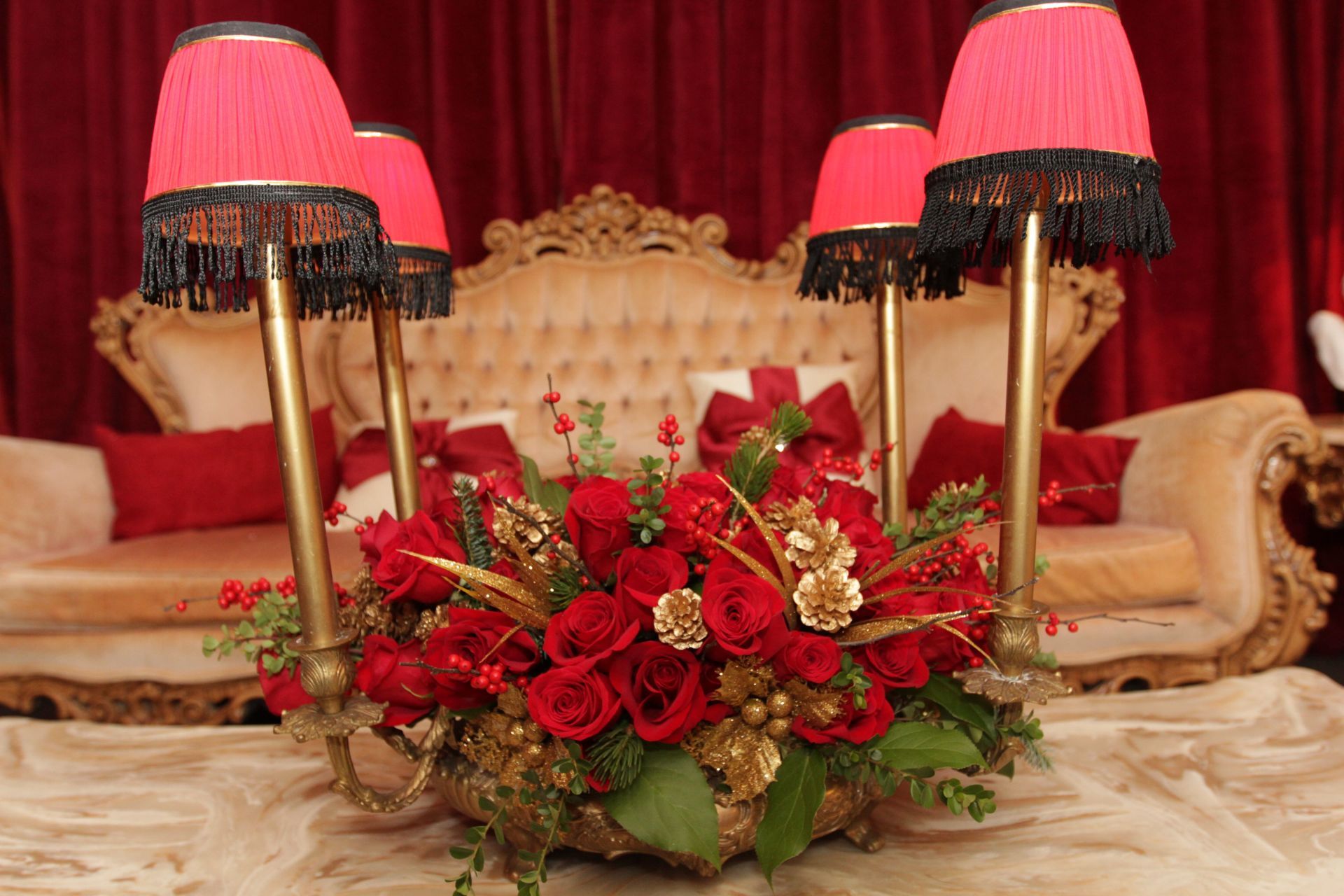 A vase of red roses is sitting on a table in front of a couch.