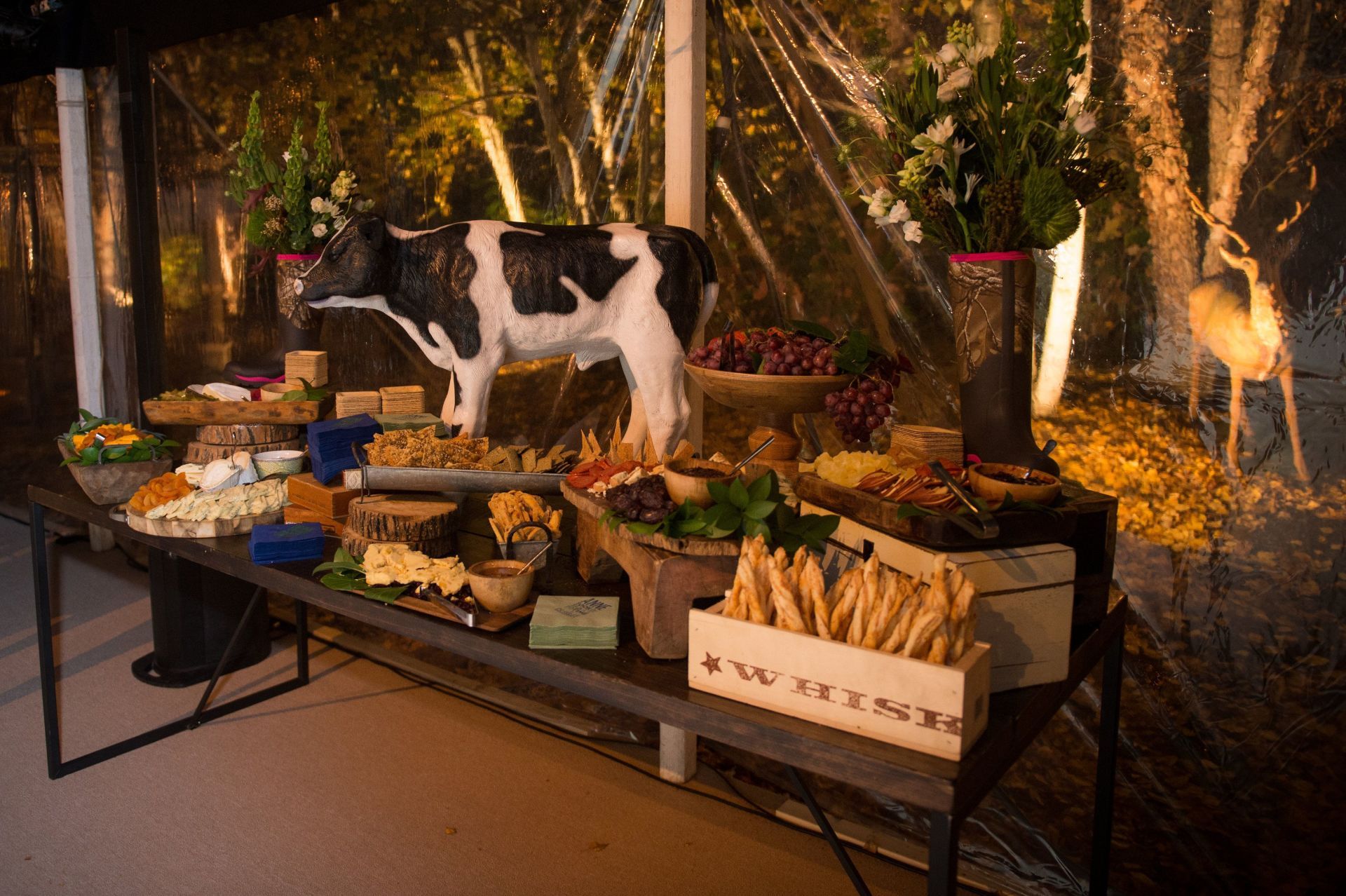 A buffet table with a cow statue on top of it.