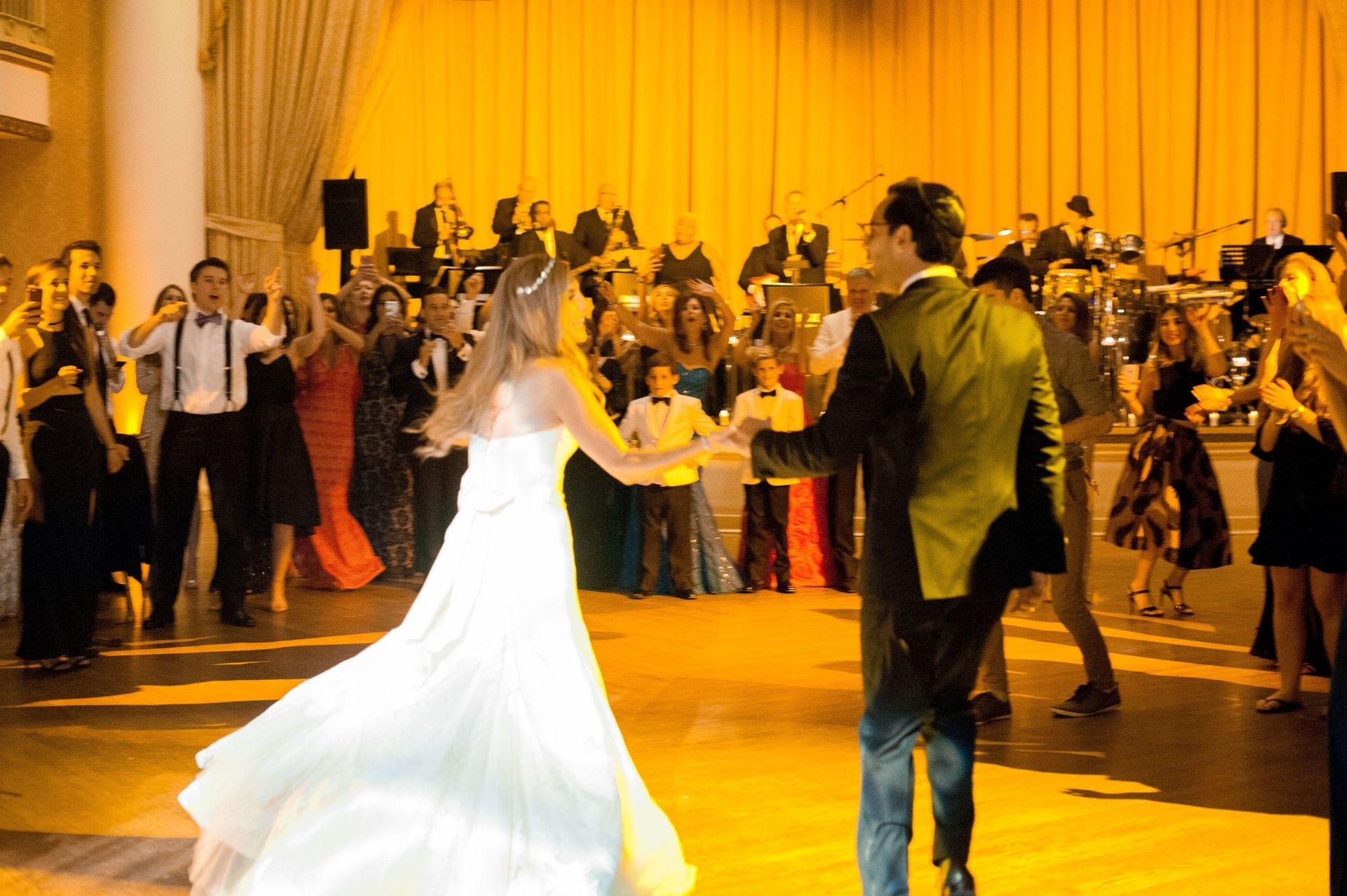 A bride and groom are dancing at a wedding reception