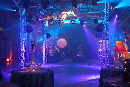 A man is flying through the air on a stage with purple lights