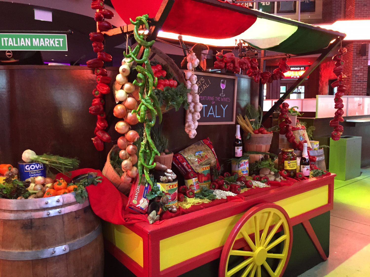 A cart with vegetables and a sign that says italian market