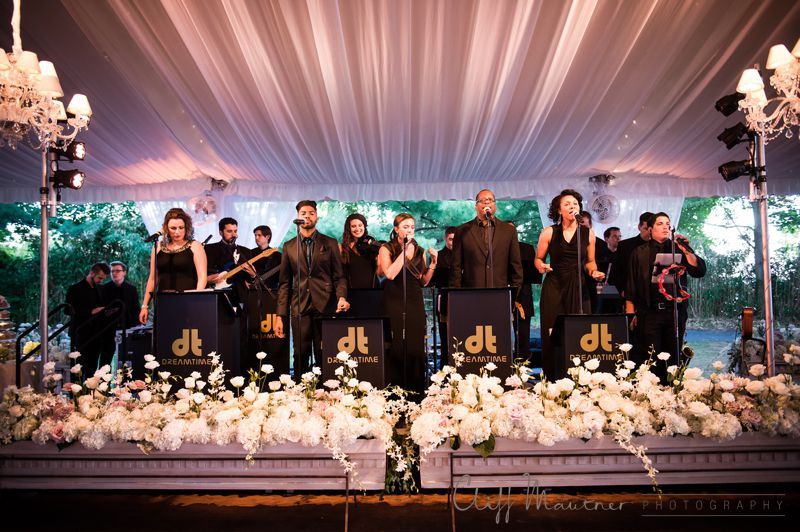 A group of people are standing on a stage under a tent.