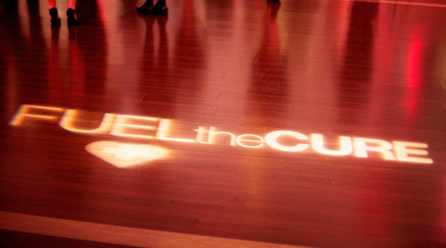 The words fuel the cure are projected on the floor