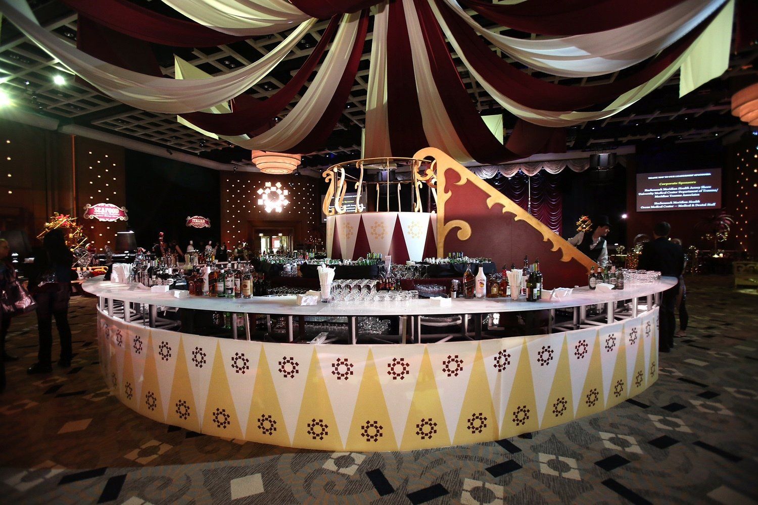 A large round bar in a room with people standing around it.