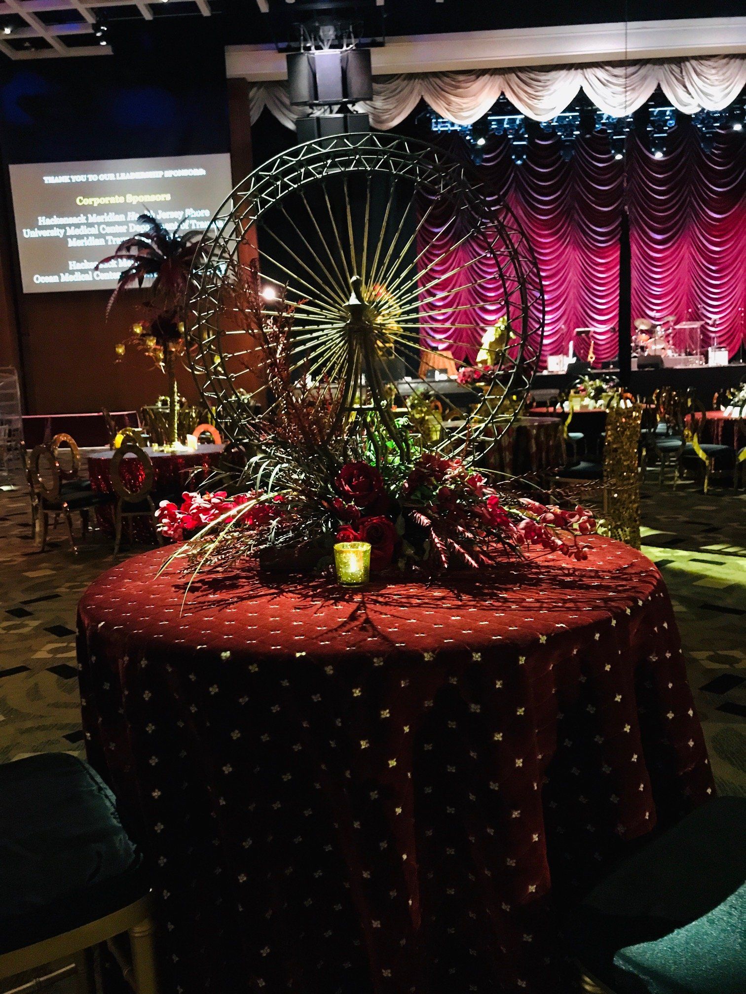 A table with flowers on it in a room with a red table cloth.
