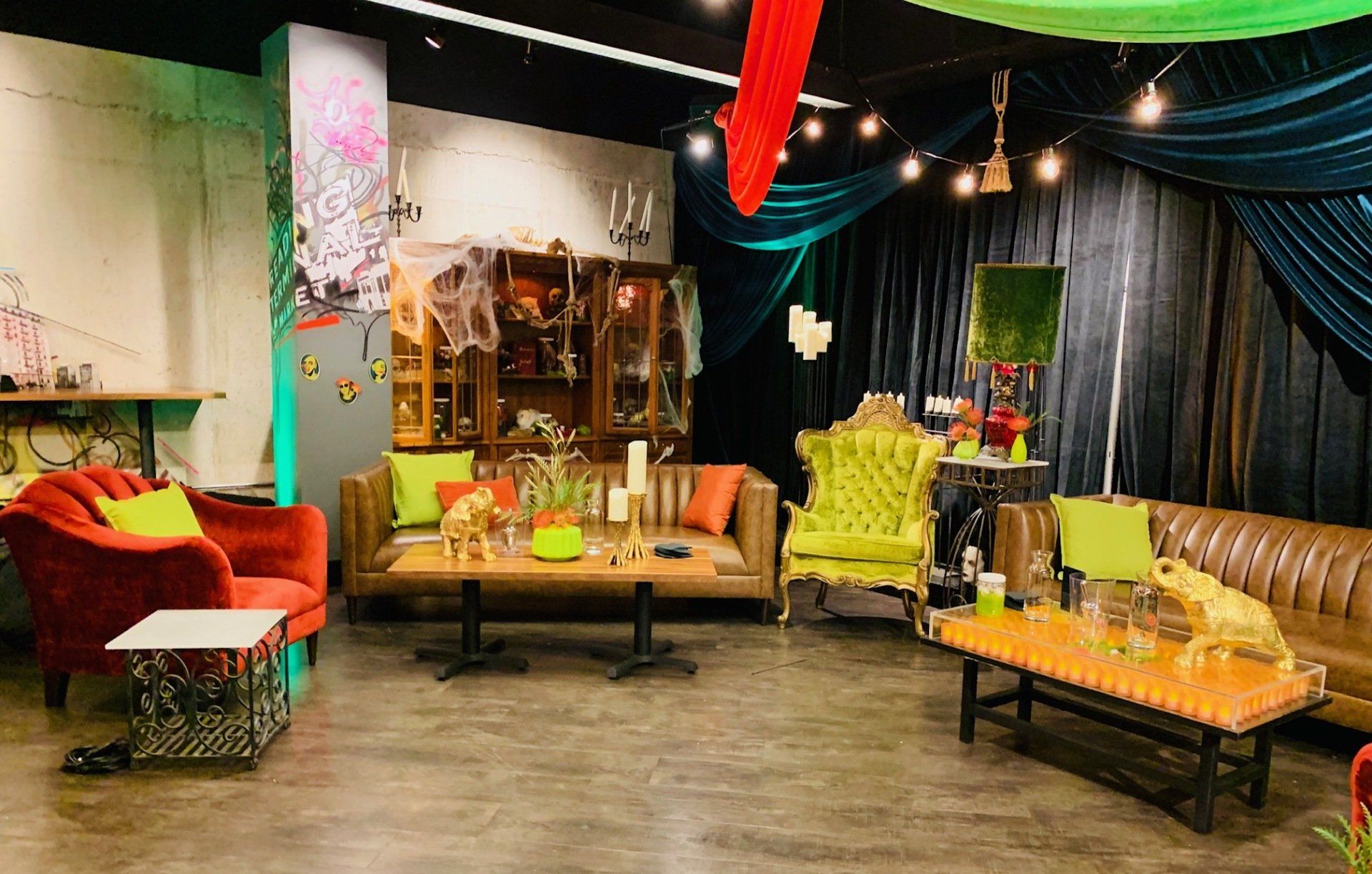 A living room with a couch , chairs , tables and a curtain.