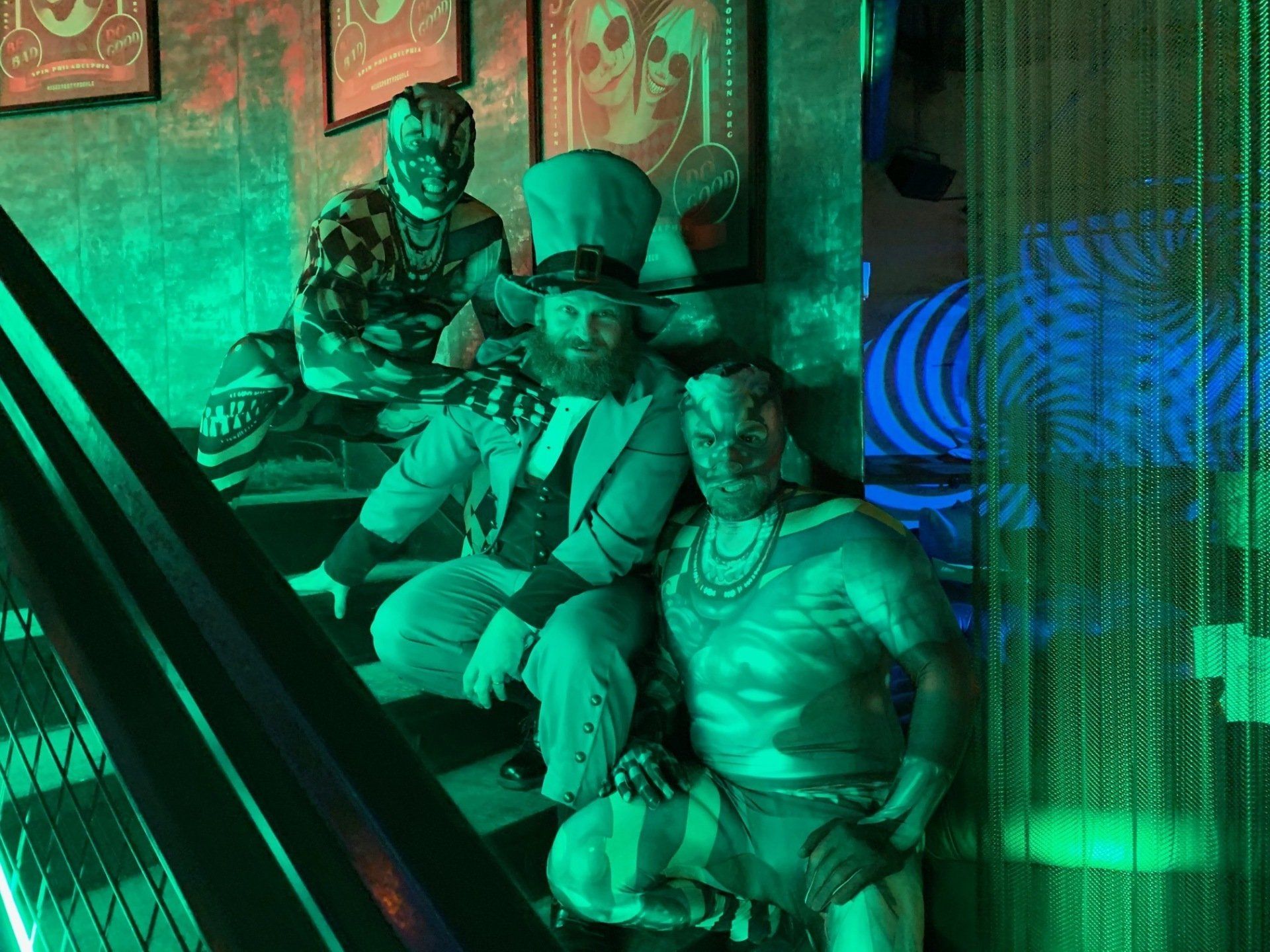 A man in a top hat is sitting next to another man in a costume.