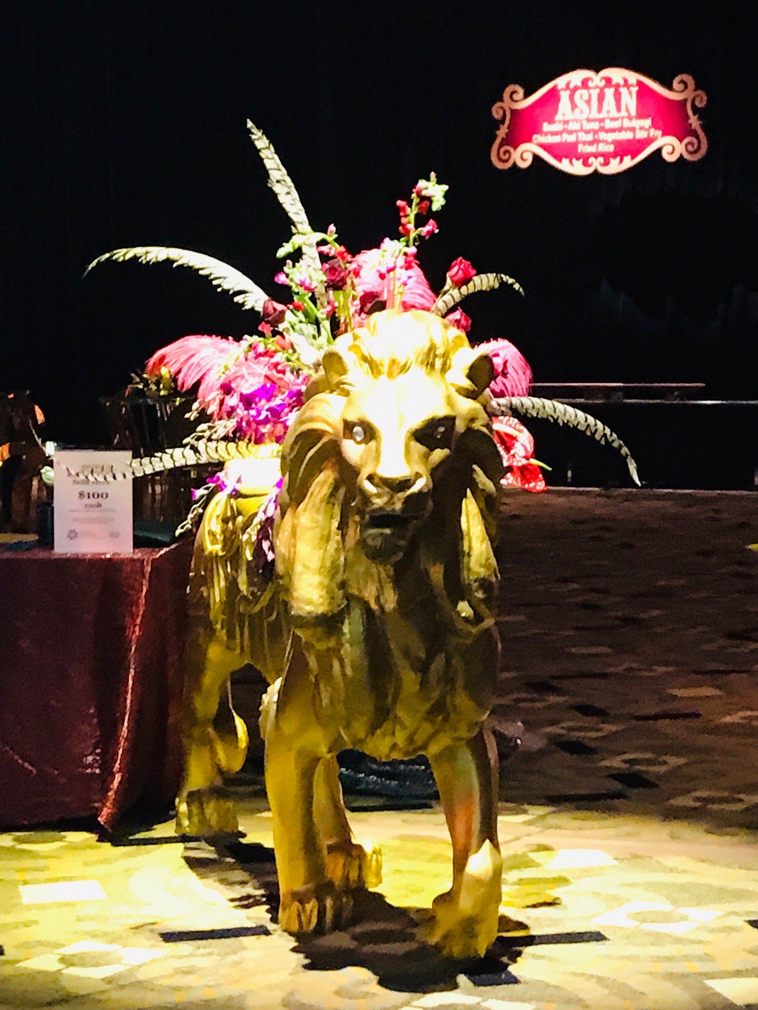 A statue of a lion is standing in front of a sign that says asian