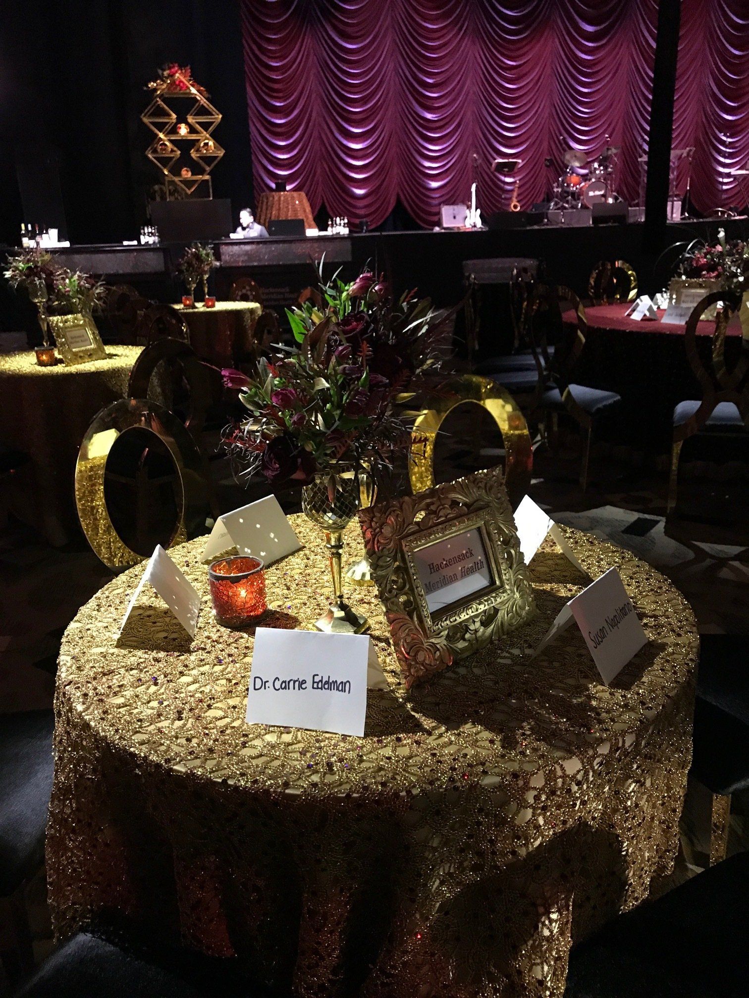 A table with a gold tablecloth and flowers on it