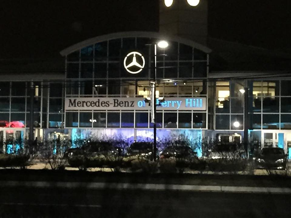 A mercedes benz dealership is lit up at night