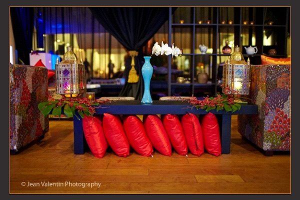 A table with red pillows and vases on it